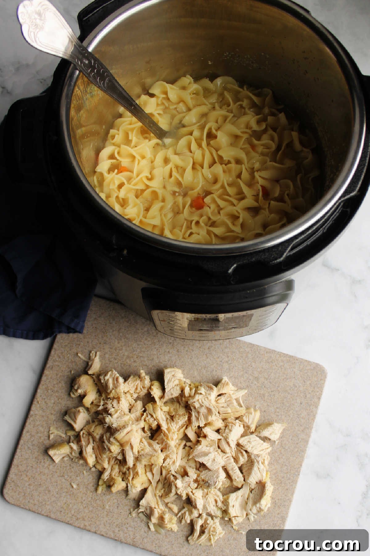 Flexible Chicken Noodle Soup: Instant Pot and Slow Cooker Ready 5 Chopped chicken, prepared and ready to be returned to a slow cooker filled with aromatic broth, cooked pasta, and tender carrots, symbolizing a meal nearly complete.