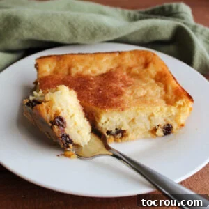 Velvety Condensed Milk Baked Rice Pudding 9 Bite of baked rice pudding with raisins on fork ready to eat.