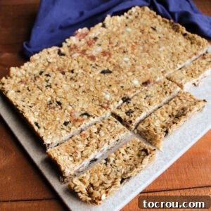A homemade sheet of cookies and cream granola being expertly sliced into thin, delicious bars, ready to be enjoyed as a perfect snack.