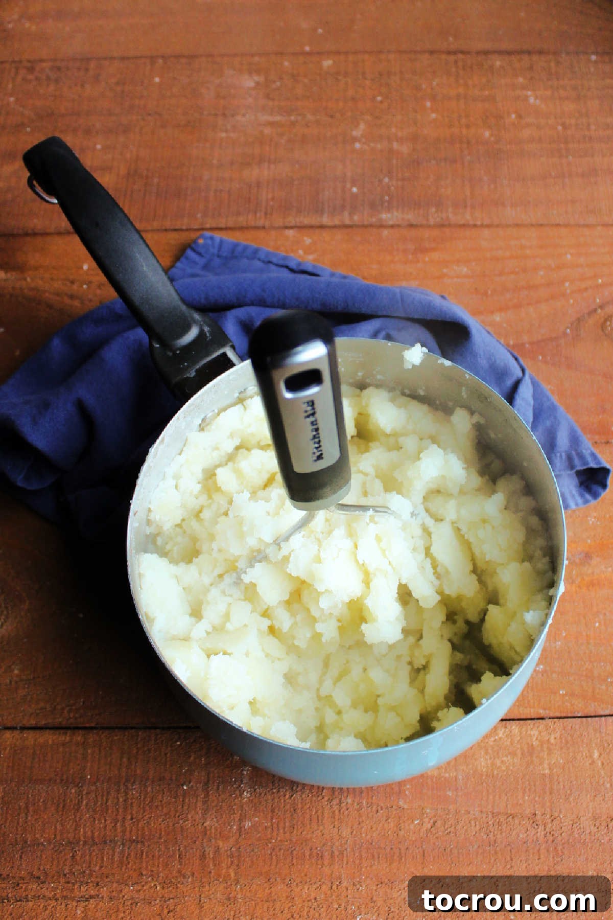 Sour Cream and Chive Smashed Potatoes 4 Potato masher mashing cooked and drained potatoes.