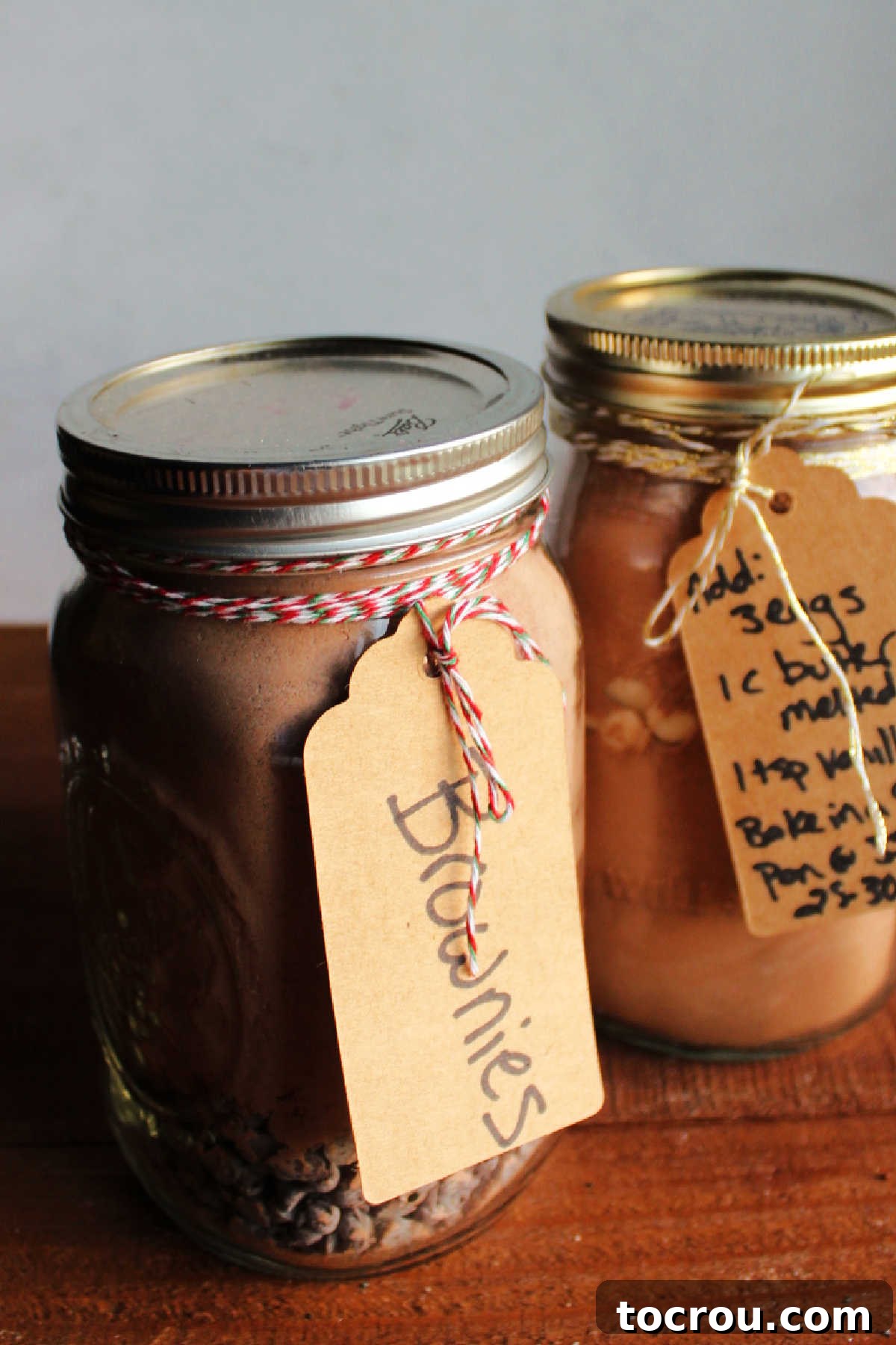 Labeled Jars of Brownie Mix Close-up of glass jars filled with homemade brownie mix, each labeled with handwritten instructions for baking.