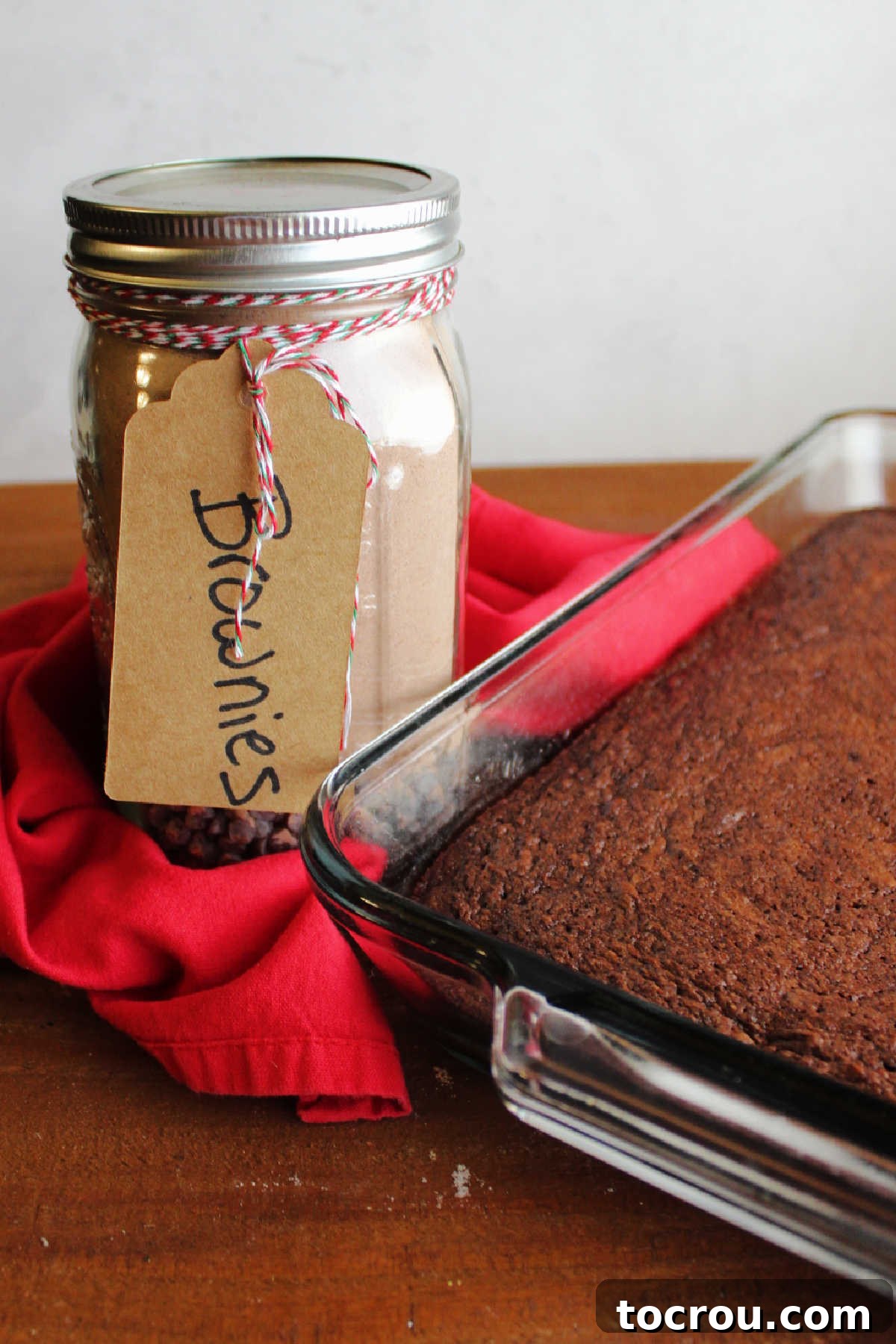 Fudgy Brownies from Homemade Mix A freshly baked pan of fudgy brownies placed in front of a jar containing homemade brownie mix, symbolizing the journey from mix to delicious treat.
