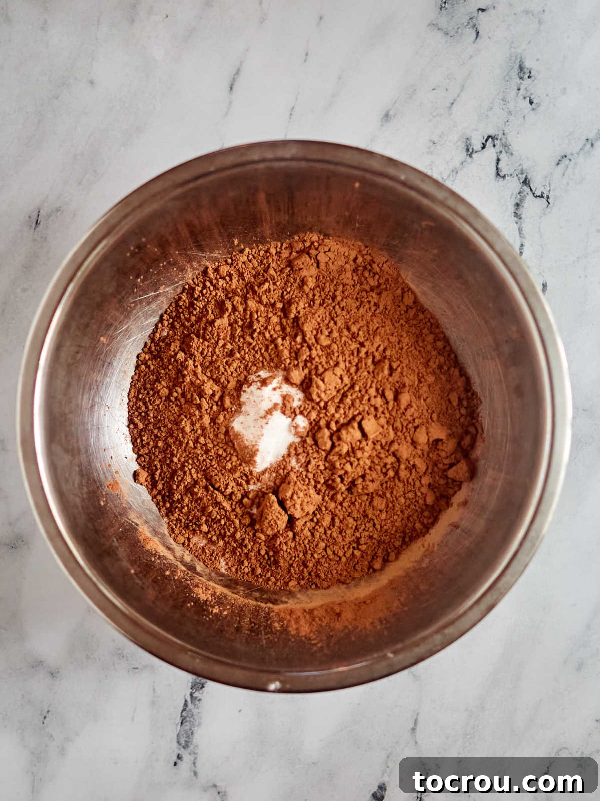 Dry Brownie Mix Ingredients Dry ingredients for homemade brownie mix in a large stainless steel mixing bowl, ready for wet ingredients.