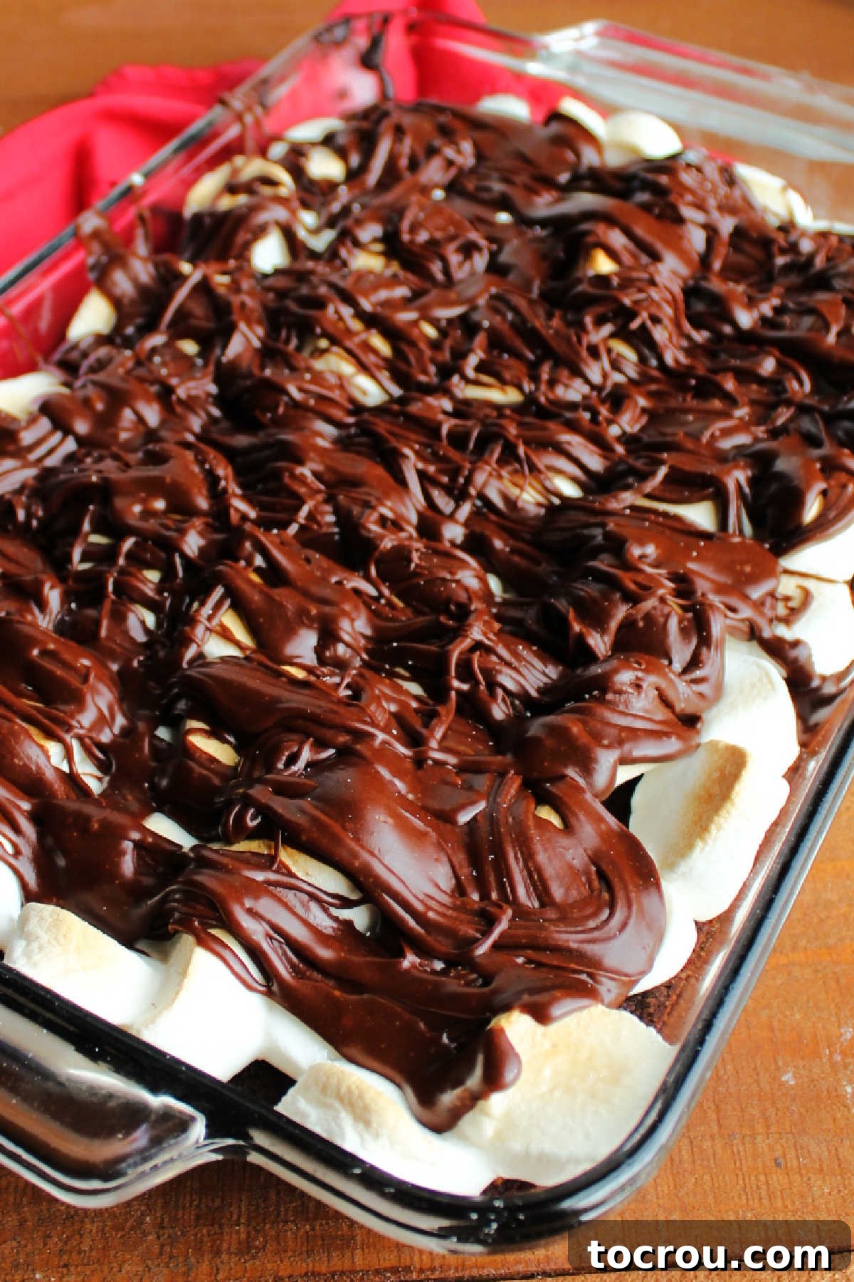Chocolate icing drizzled over marshmallows and brownies.