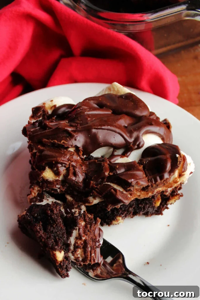 Bite of Mississippi mud brownie on a fork showing rich chocolate base with gooey marshmallows and fudge on top. 