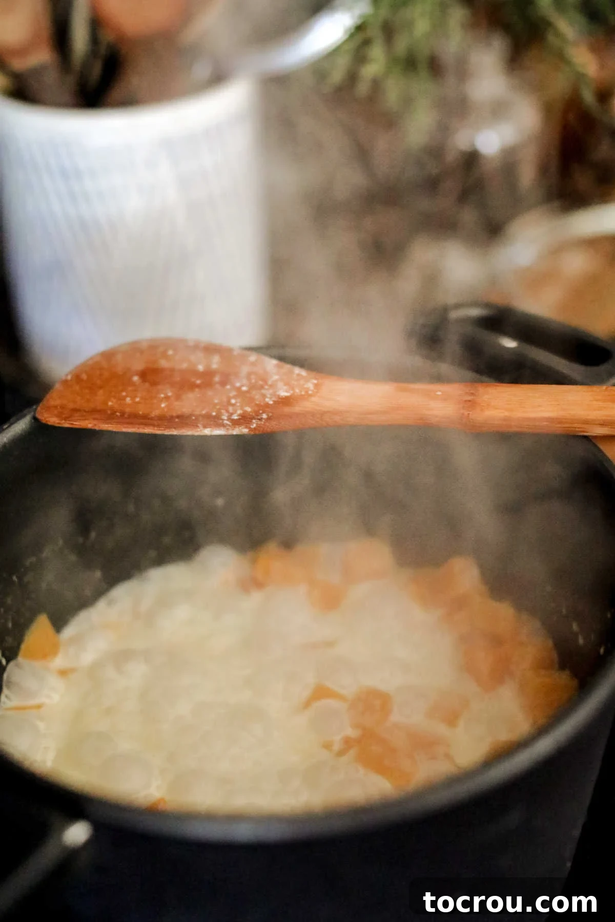 Butternut squash cubes gently simmering in a rich cream mixture, slowly softening to create the base of the sauce.