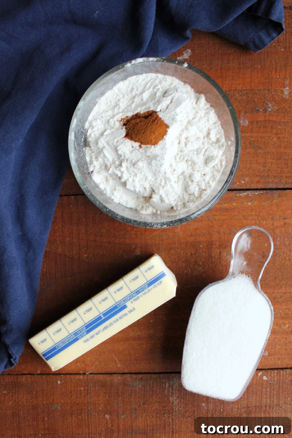 Ingredients for a delectable crumb topping, including softened butter, granulated sugar, all-purpose flour, and a touch of cinnamon, awaiting preparation.
