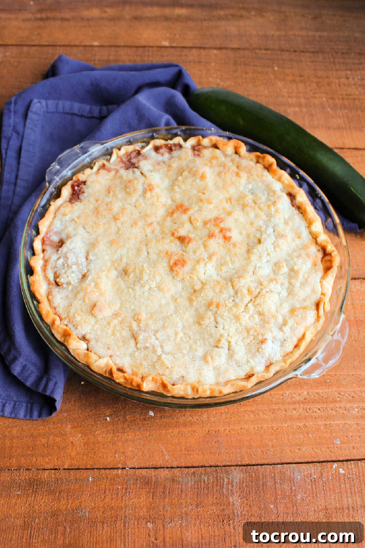 A freshly baked zucchini mock apple pie, boasting a golden-brown, irresistibly crumbly topping, straight from the oven.