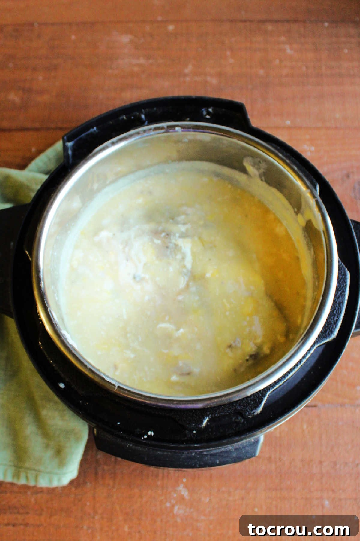 Fork Tender Pork Loin with Velvety Gravy 6 Pork loin cooked in creamy gravy inside slow cooker, ready to remove and slice.