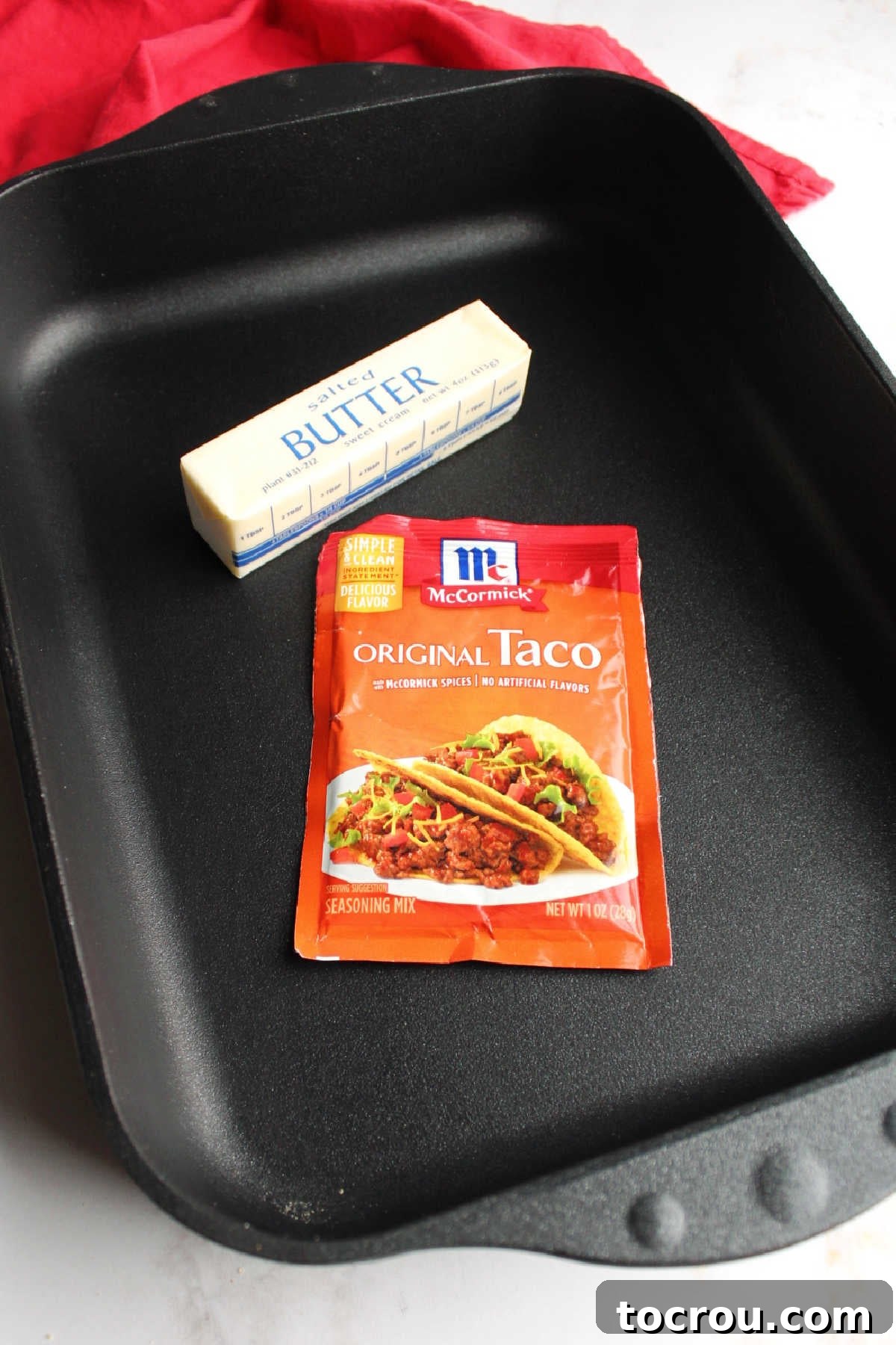 Packet of taco seasoning and stick of butter in roasting pan.