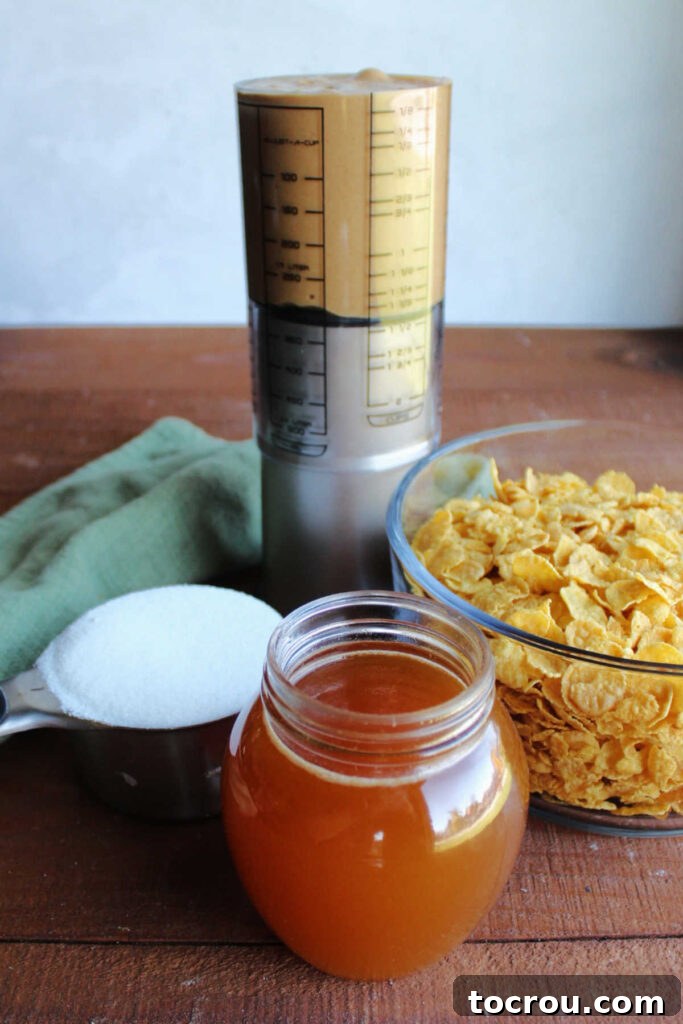 Honey, granulated sugar, creamy peanut butter, and cornflakes laid out neatly on a surface, ready to be transformed into delicious no-bake cookies.