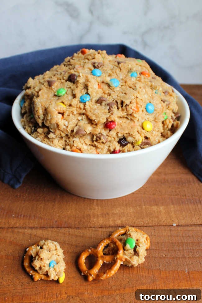 bowlful of monster cookie dough dip with pretzels for dipping
