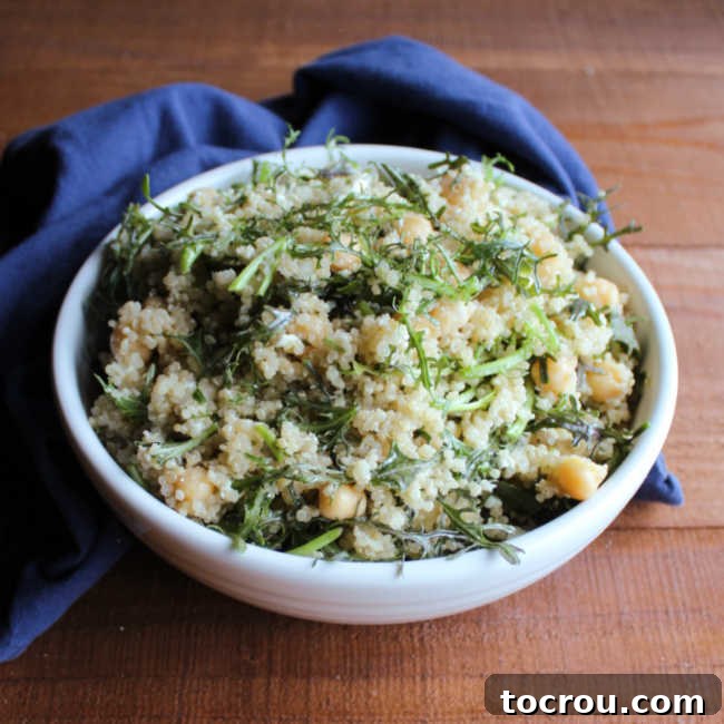 Close-up of a vibrant bowl of Mizuna Greens and Quinoa Salad featuring fresh greens, fluffy quinoa, wholesome chickpeas, and crumbled feta cheese.