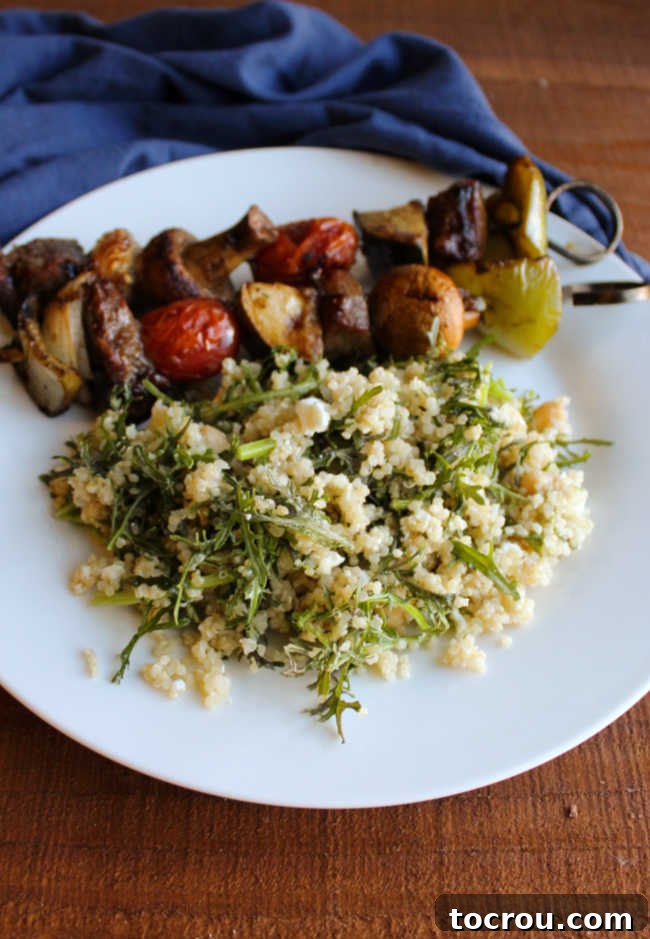 Mizuna Greens and Quinoa Salad served alongside grilled meat and vegetable skewers, highlighting its versatility as a side dish.