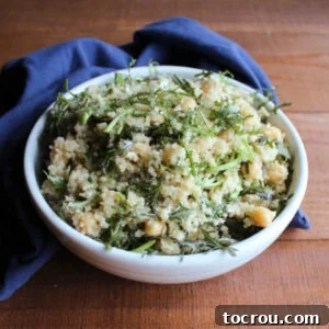 Close-up of a vibrant bowl of Mizuna Greens and Quinoa Salad featuring fresh greens, fluffy quinoa, wholesome chickpeas, and crumbled feta cheese.