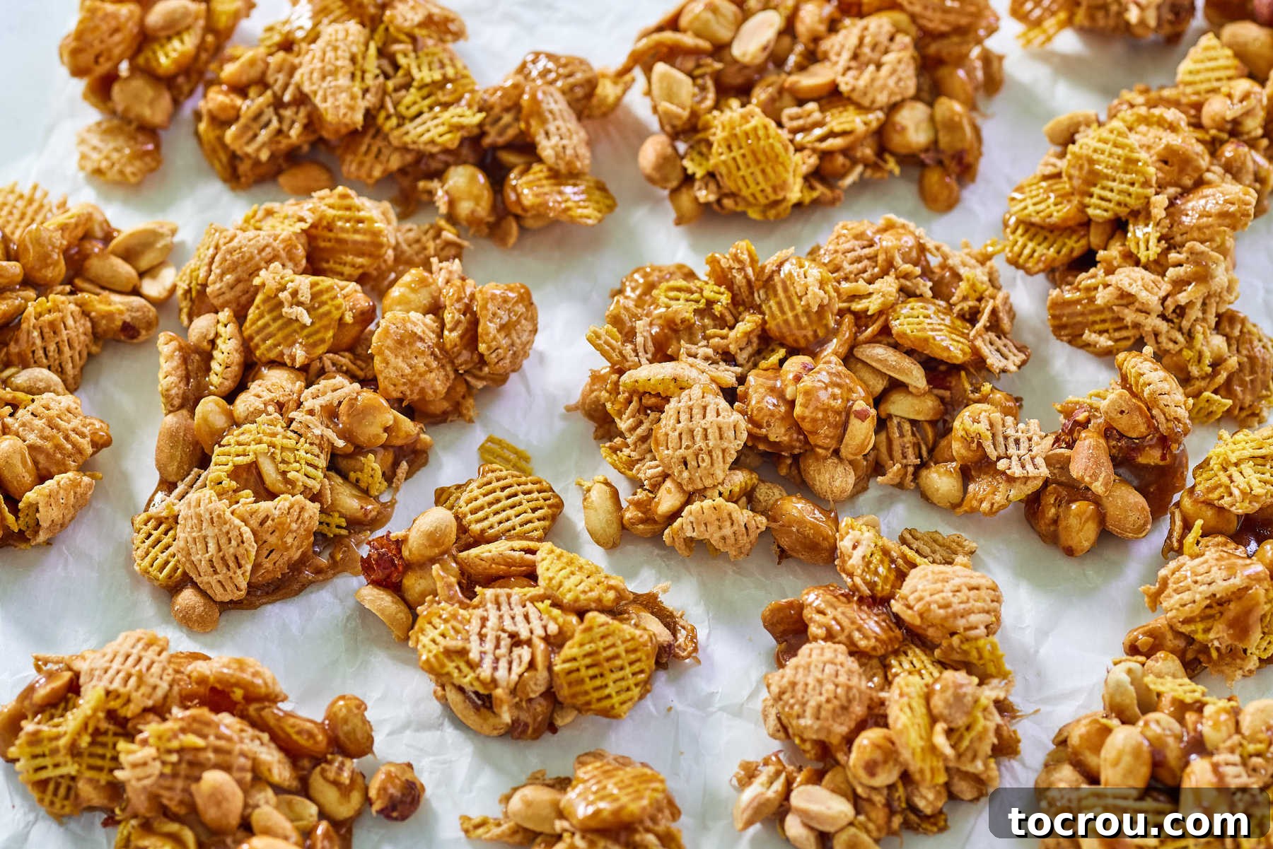 Microwave Caramel Crispix Mix Clusters of hardened caramel coated Crispix cereal and peanuts, ready to eat. A perfect example of homemade Microwave Caramel Crispix Mix.