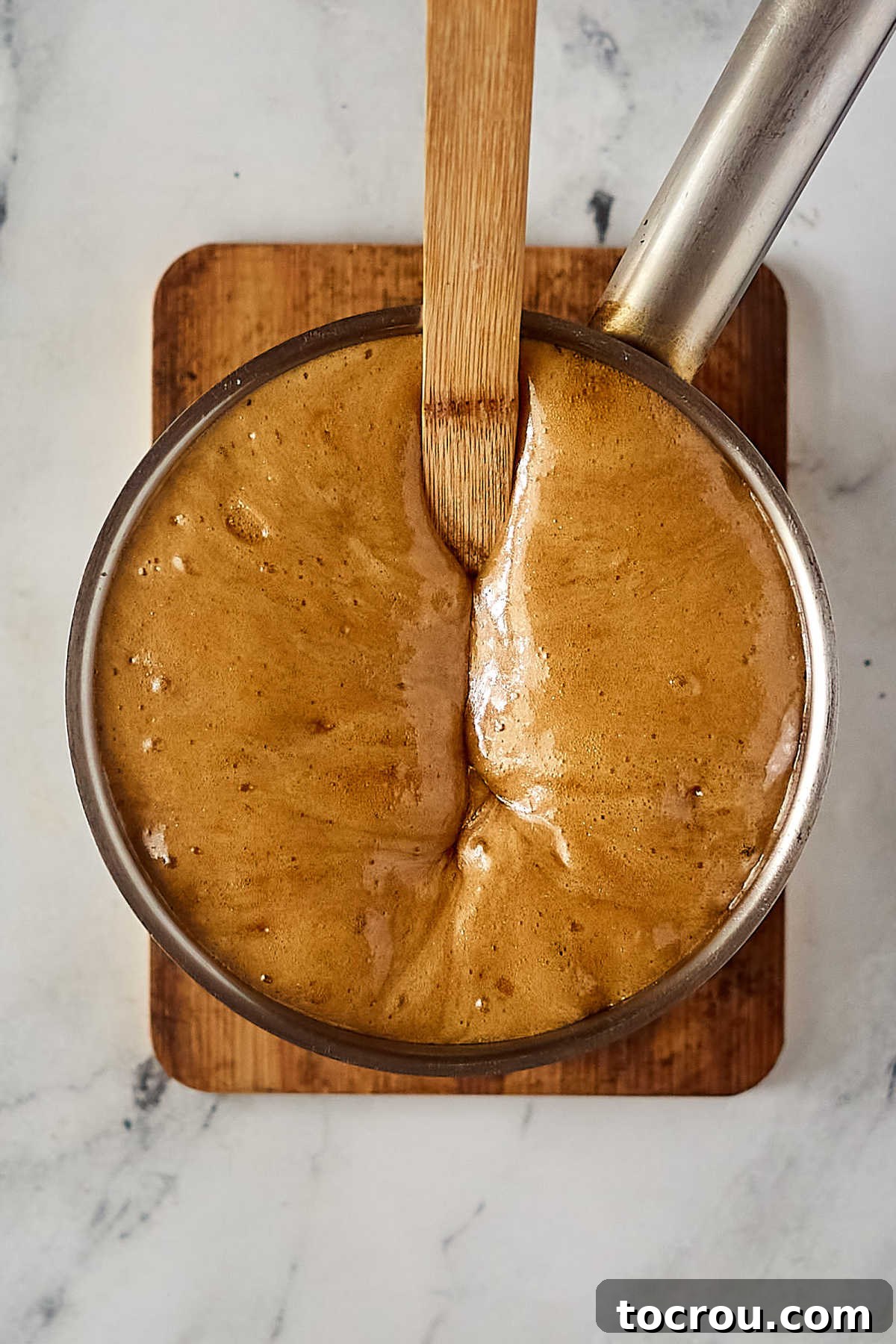 Caramel Foaming with Baking Soda Saucepan after baking soda has been added and the caramel mixture has foamed up and almost filled the pan. Illustrating the reaction of baking soda.