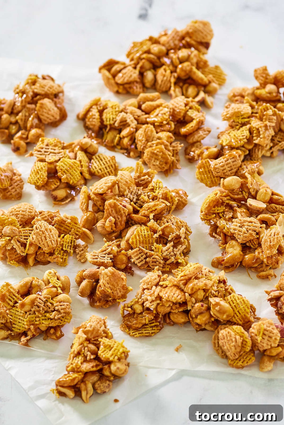 Ready-to-Eat Caramel Crispix Clusters of caramel coated peanuts and Crispix ready to eat, piled high for an inviting snack. Highlight of the Crispix and Peanut Caramel Mix.