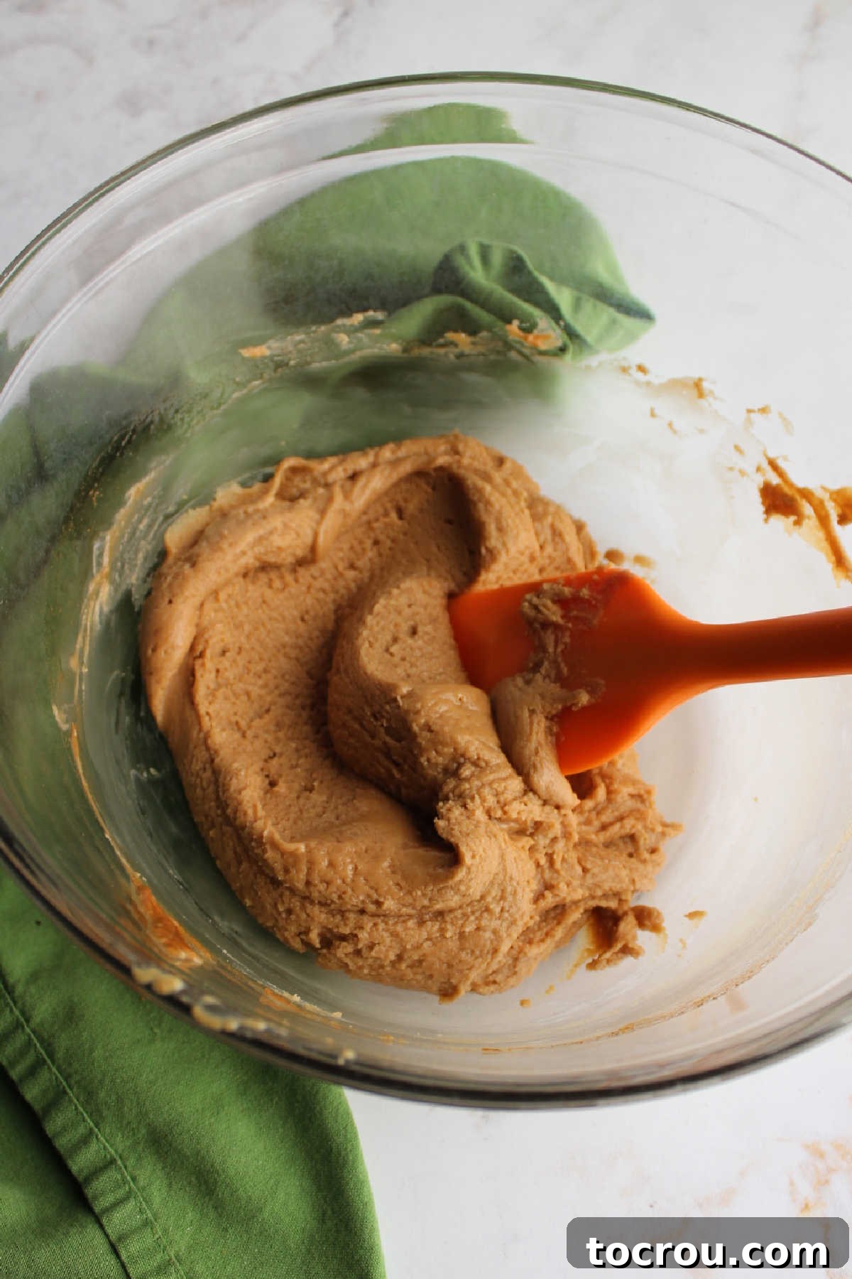 Bowl of melted peanut butter maple cinnamon mixture ready for cereal.