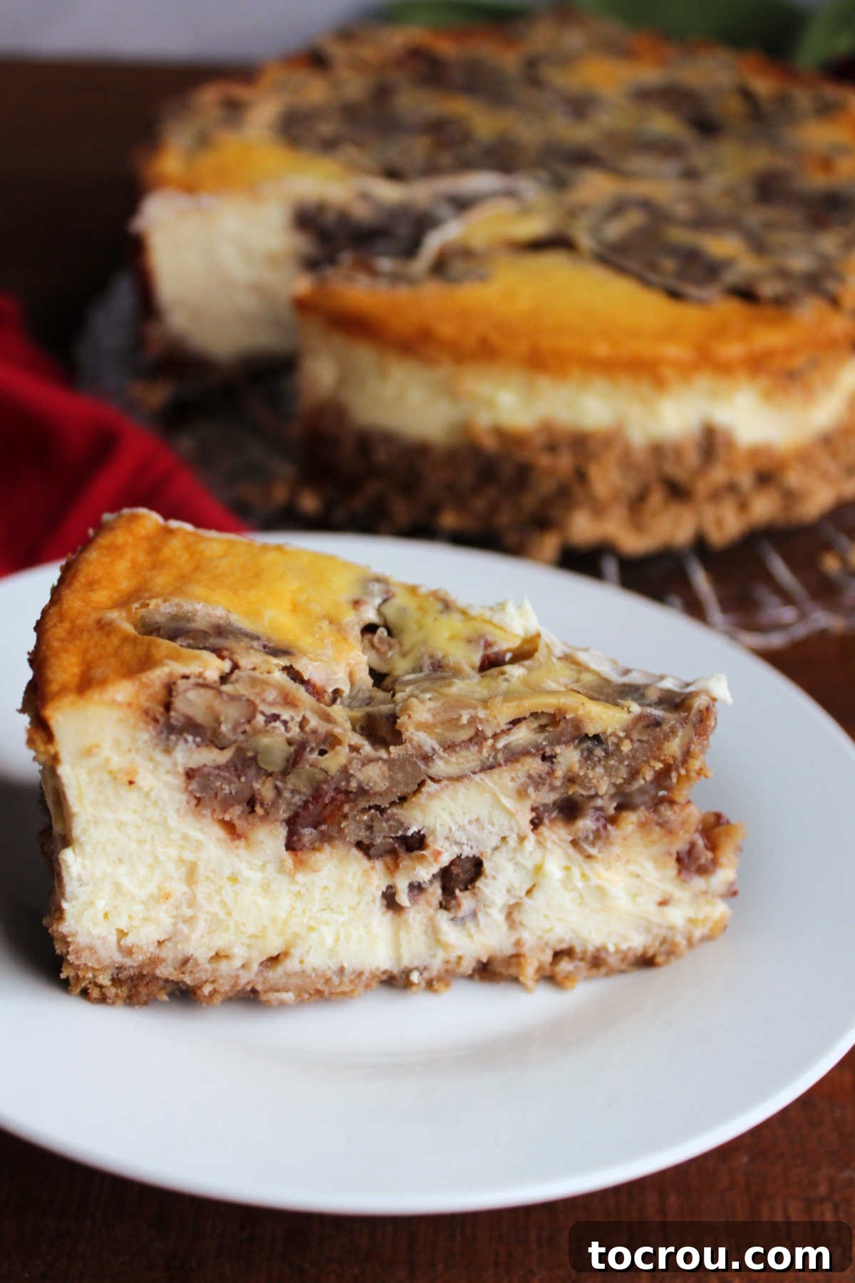 Slice of pecan pie cheese cheesecake served on small white plate ready, to eat.