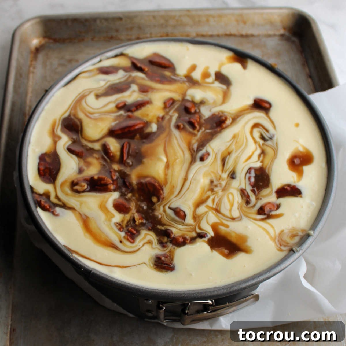 Brown sugar pecan mixture swirled in cheesecake batter ready to bake.