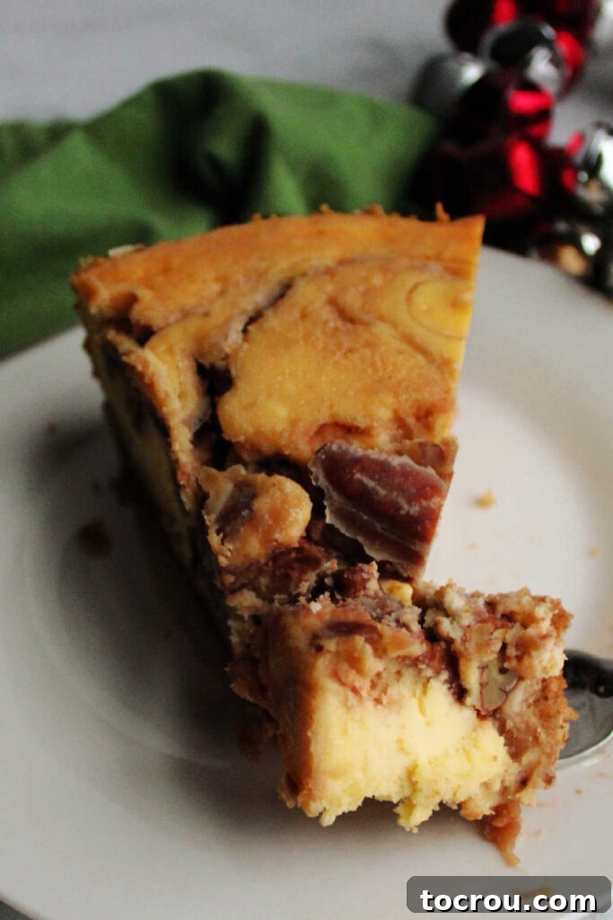 Bite of pecan pie cheesecake on fork, ready to eat.