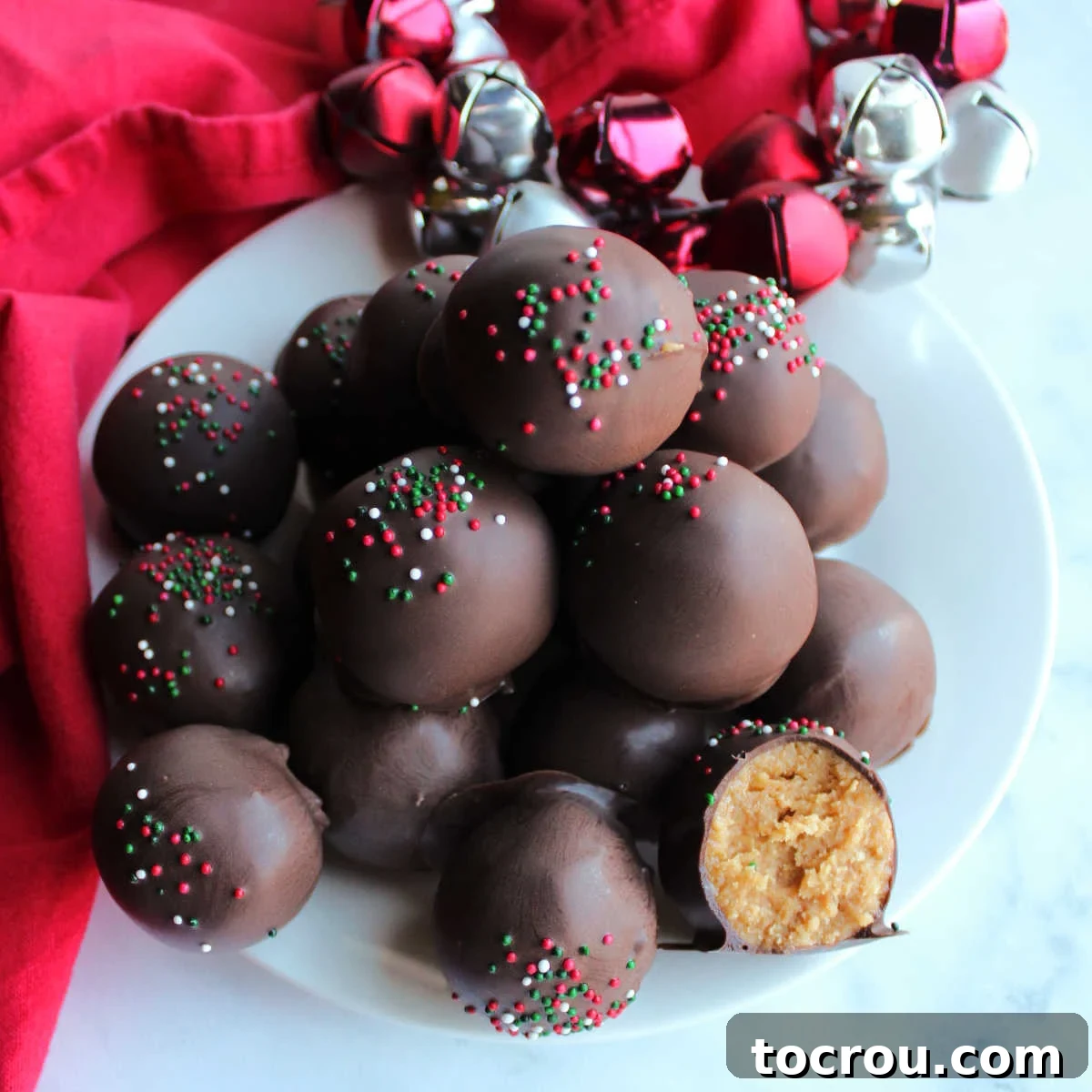 Plate of chocolate-dipped Nutter Butter truffles with the creamy peanut butter center of one showing.