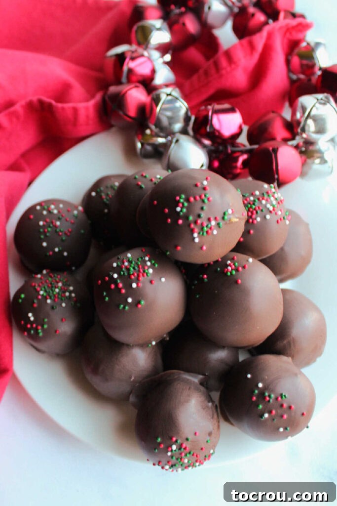 Plate piled high with sprinkle-topped chocolate-dipped peanut butter cookie balls.