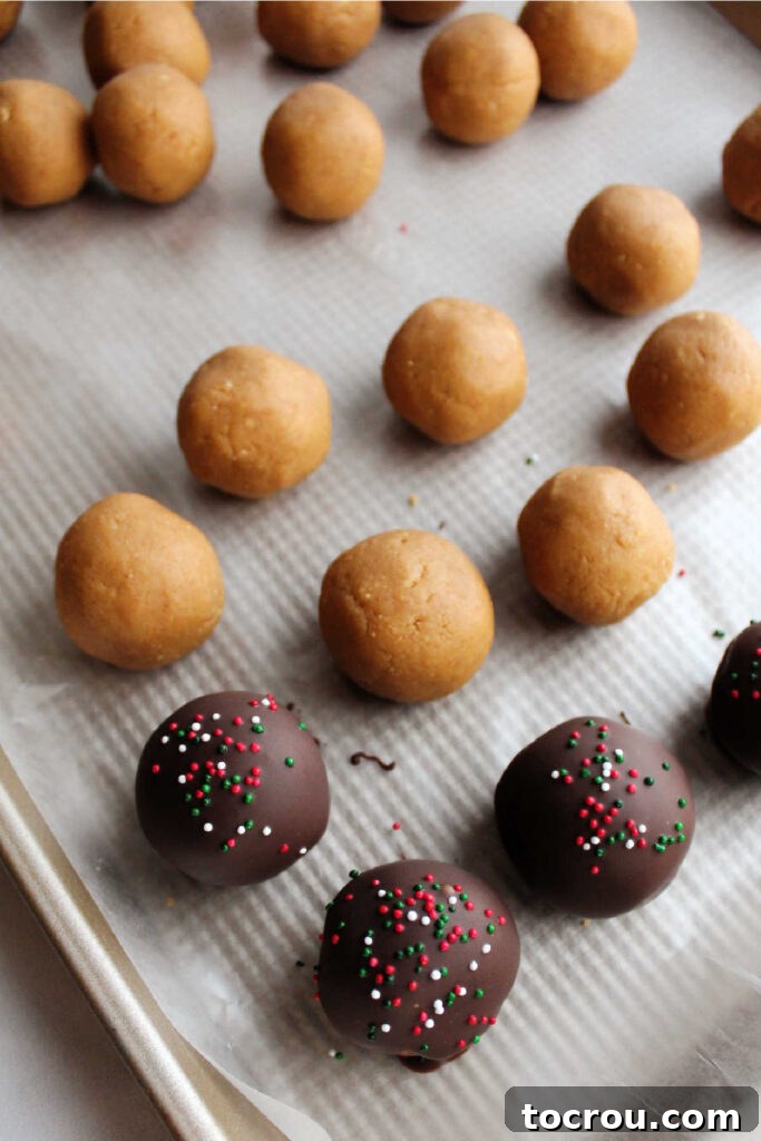 Tray of Nutter Butter truffles, half dipped in chocolate and topped with sprinkles, the other half waiting to be dipped.