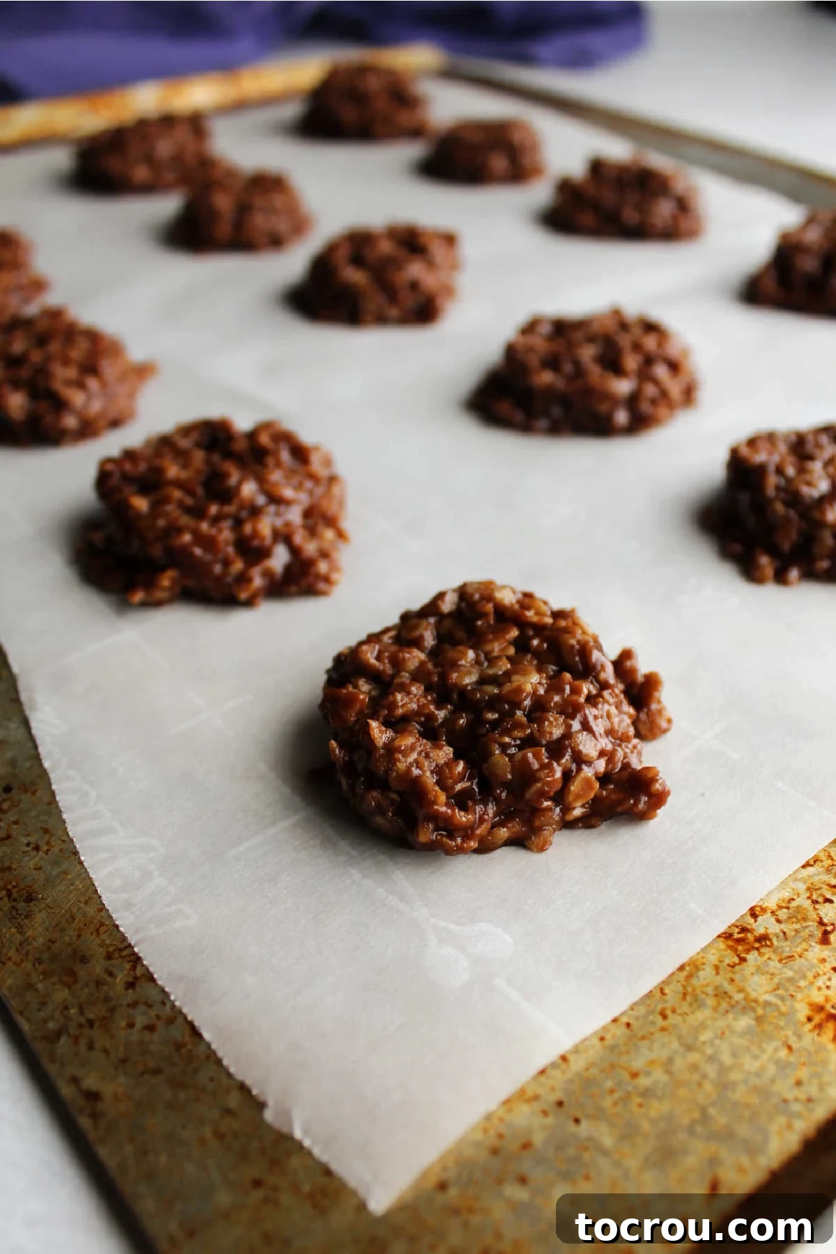 Chocolate Peanut Butter No-Bake Oatmeal Delights 4 scoops of chocolate peanut butter no bake cookie mixture on wax paper.