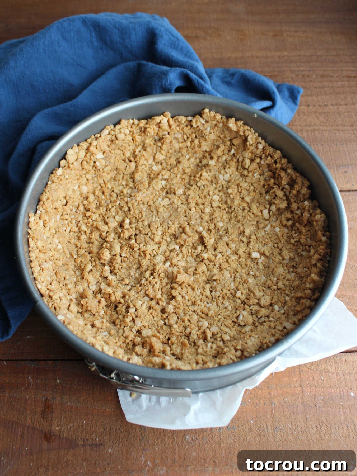 Cheesecake Crust in Springform Pan Peanut butter cookie crumbs, toffee bits, and melted butter pressed into springform pan to form crust for cheesecake.