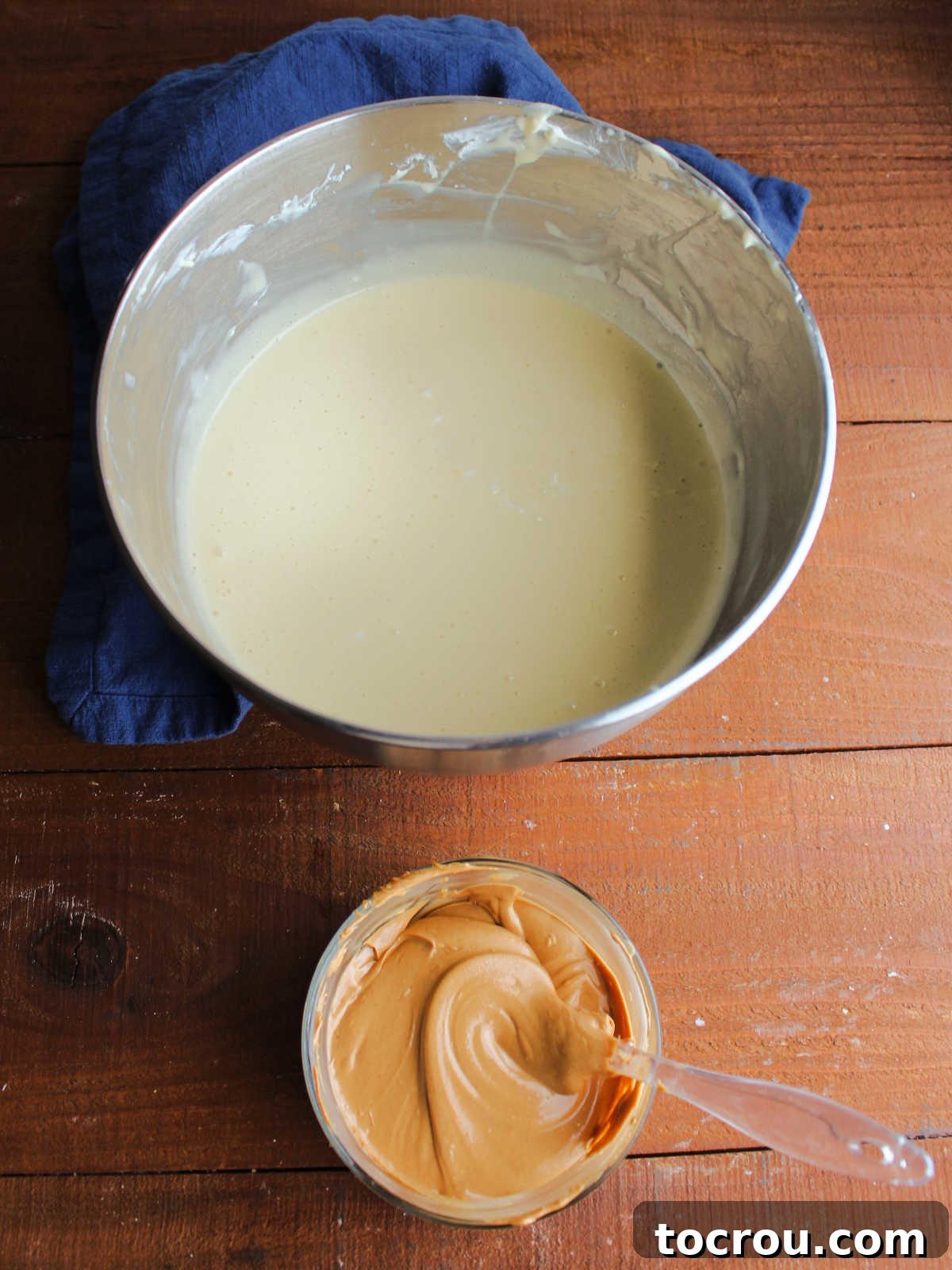 Peanut Butter Cheesecake Batter Mixer bowl with condensed milk cheesecake batter inside next to small bowl of melted peanut butter chips.