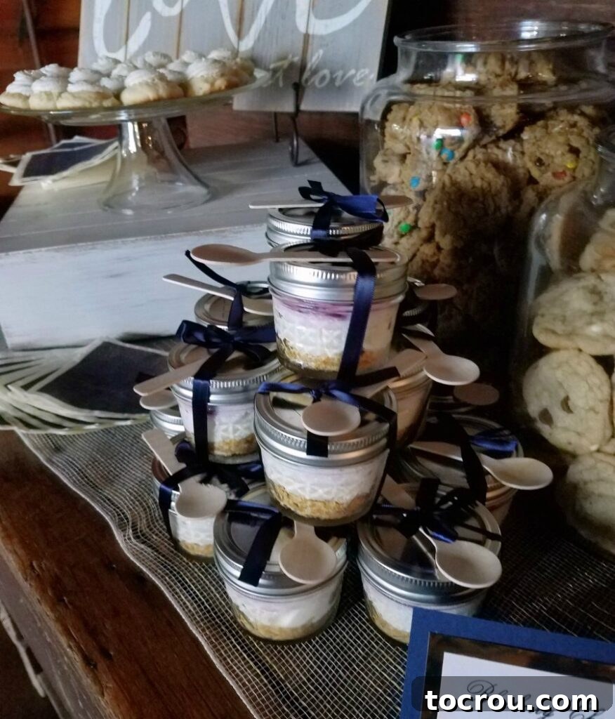 Quick Lemon Berry Jar Cheesecakes 3 stack of lemon blueberry cheesecake jars with navy ribbon and bamboo spoons