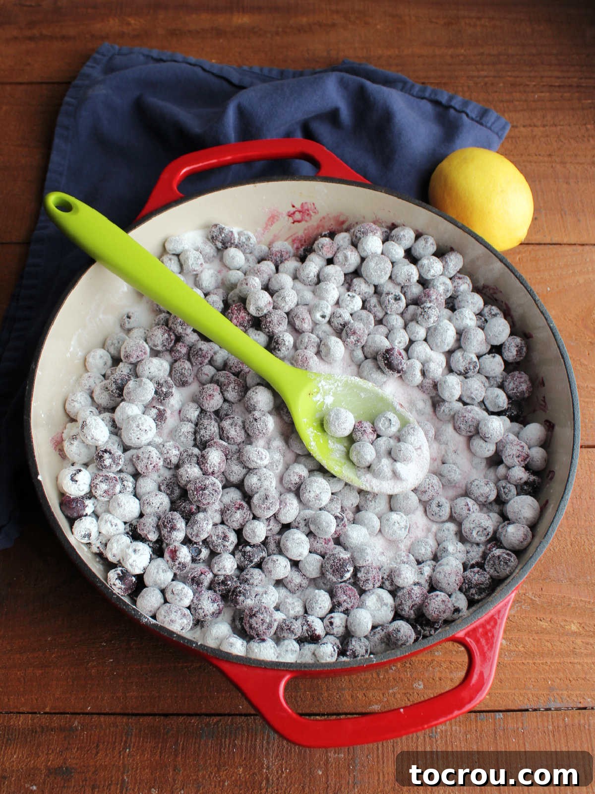 Quick Lemon Berry Jar Cheesecakes 7 Cast iron braiser filled with frozen blueberries coated in sugar and powdered sugar.