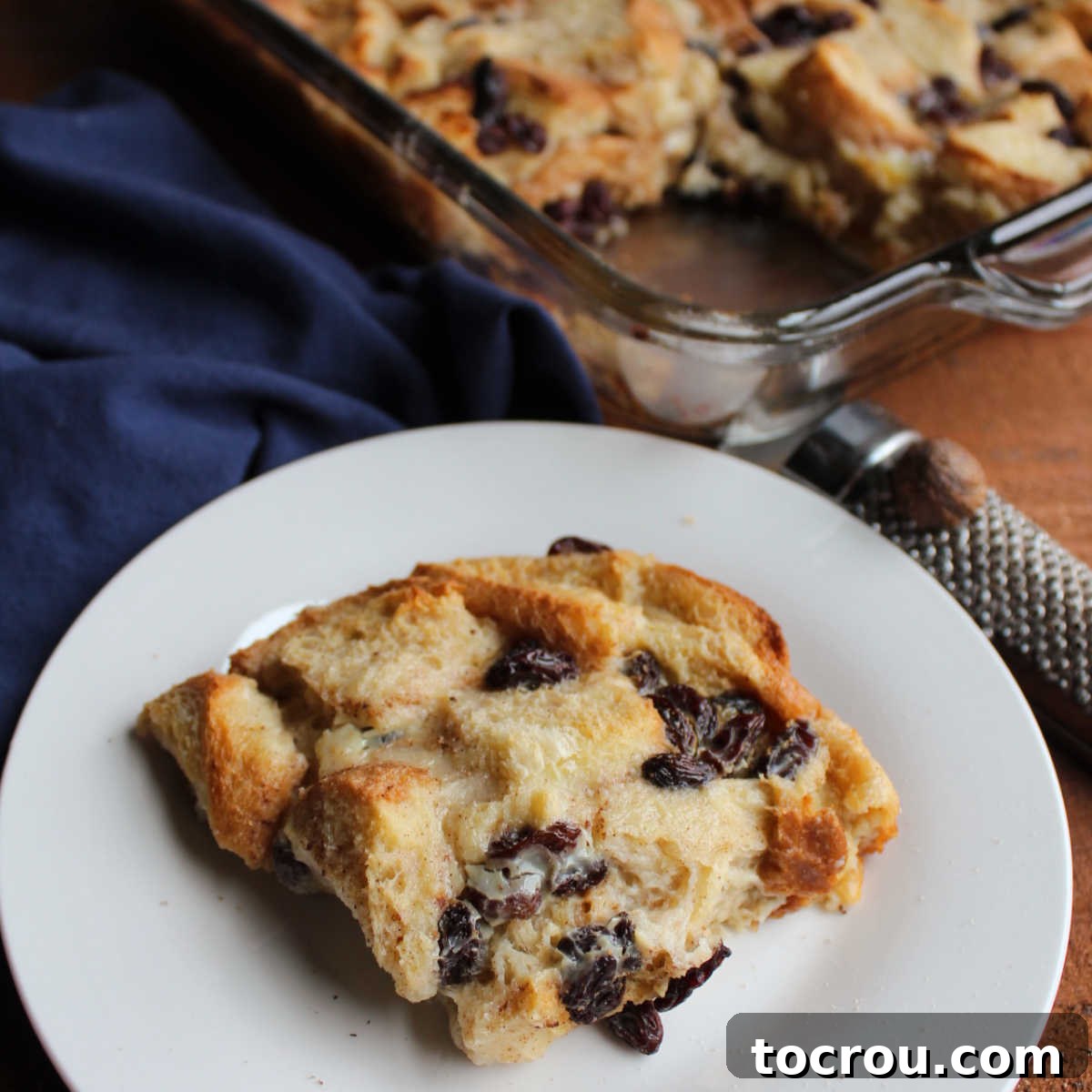 Piece of bread pudding with condensed milk custard showing toasted tips of the bread and the soft underneath.