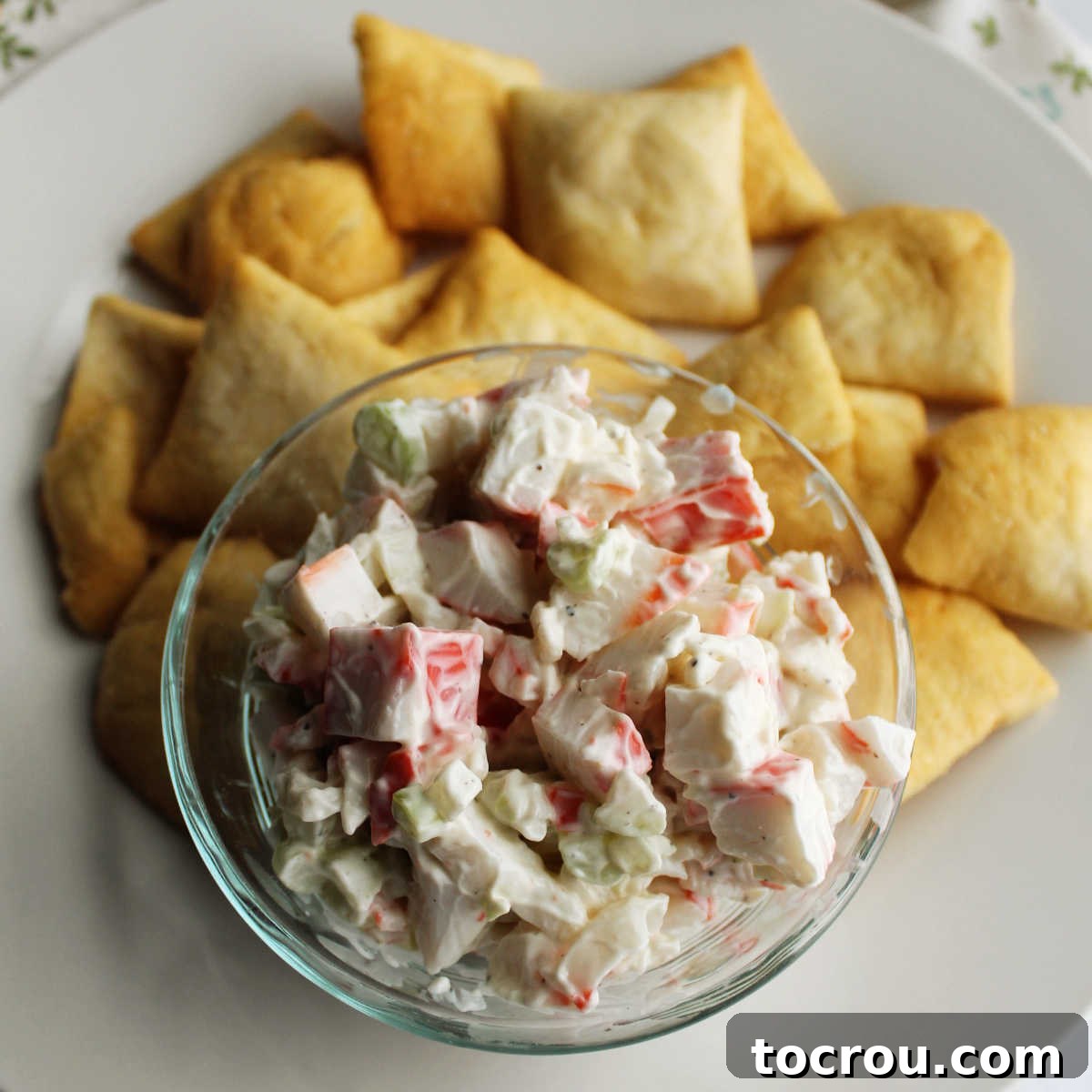 Kani Salad 2 Bowl of imitation crab salad on plate with pita chips ready to eat.