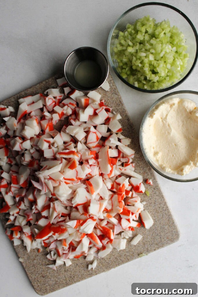 Kani Salad 6 Cutting board filled with chopped crab next to bowls of mayonnaise, chopped celery and lemon juice.