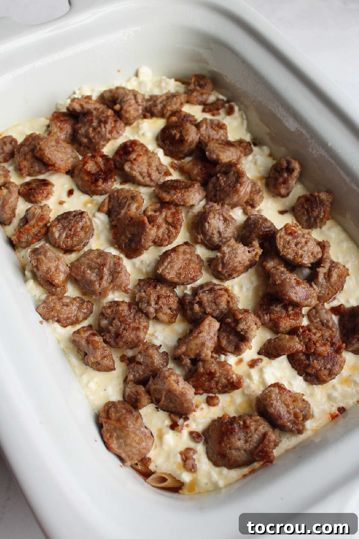 Layer of cream cheese mixture and browned Italian sausage over pasta in crockpot.