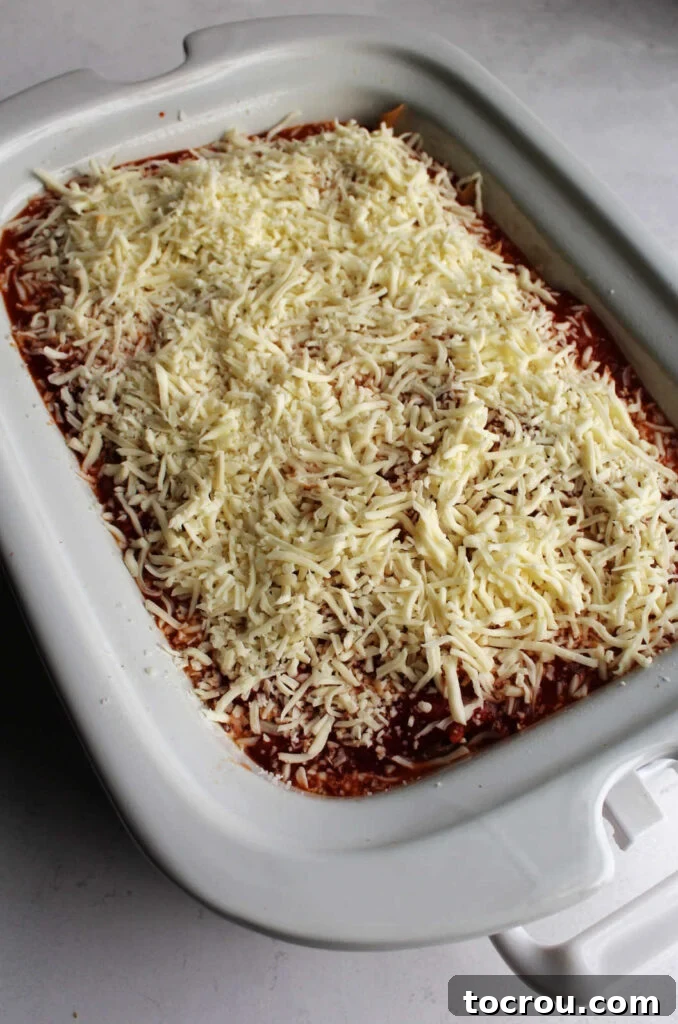 Shredded mozzarella over pasta in slow cooker.