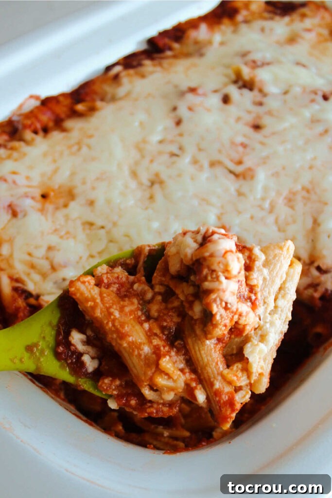 Spoonful of crockpot penne with cheese and sausage ready to serve.