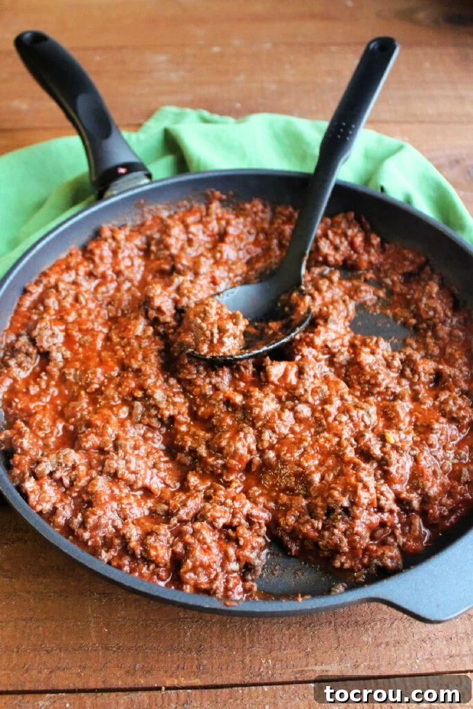 Pizza Burger Bites 3 Skillet filled with browned ground meat and pizza sauce.