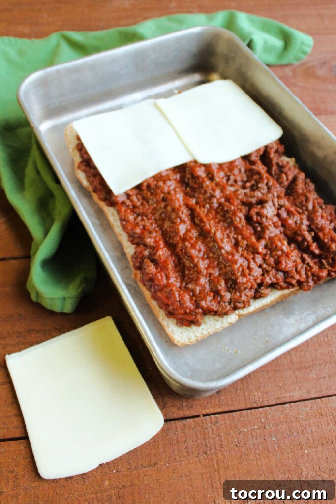 Pizza Burger Bites 4 Layering meat and cheese over dinner rolls.