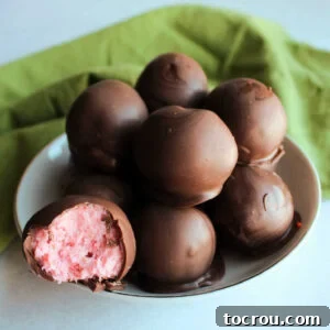 Bowlful of truffles, one with the pink strawberry buttercream center showing.