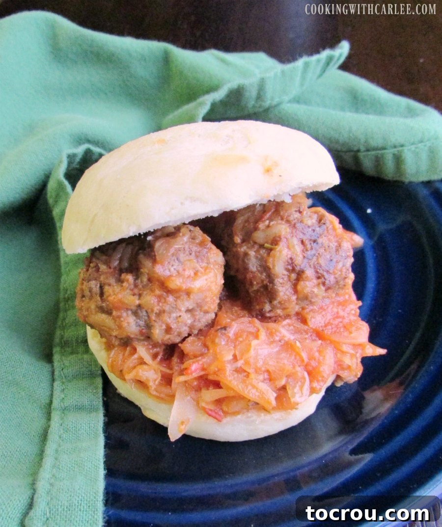 A delectable porcupine meatball sandwich served on a soft potato roll, showcasing the tender meatballs and rich secret sauce, inviting a satisfying bite.