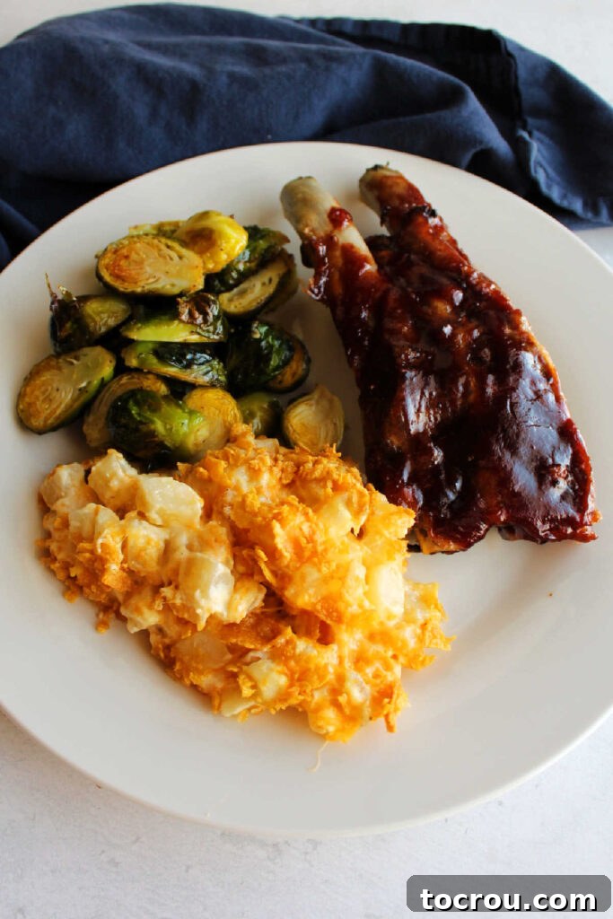 Complete Dinner Plate Dinner plate filled with cheddar ranch potato casserole, brussels sprouts and bbq ribs ready to eat.