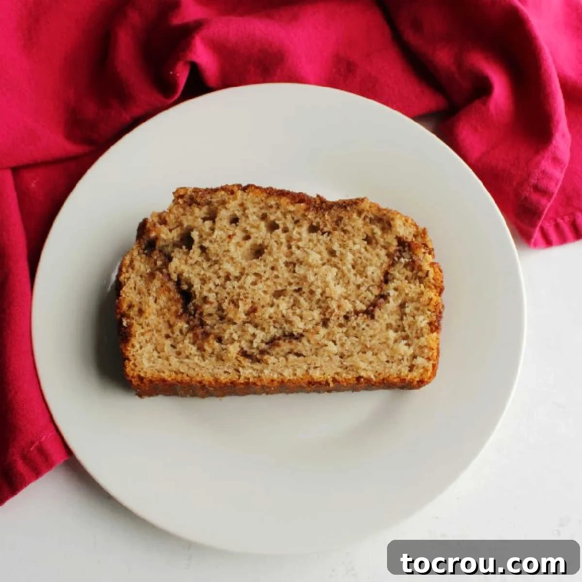Indulge in the simple pleasure of homemade cinnamon sugar quick bread, a delightful treat for any time of day. slice of cinnamon swirl bread on small plate ready to eat