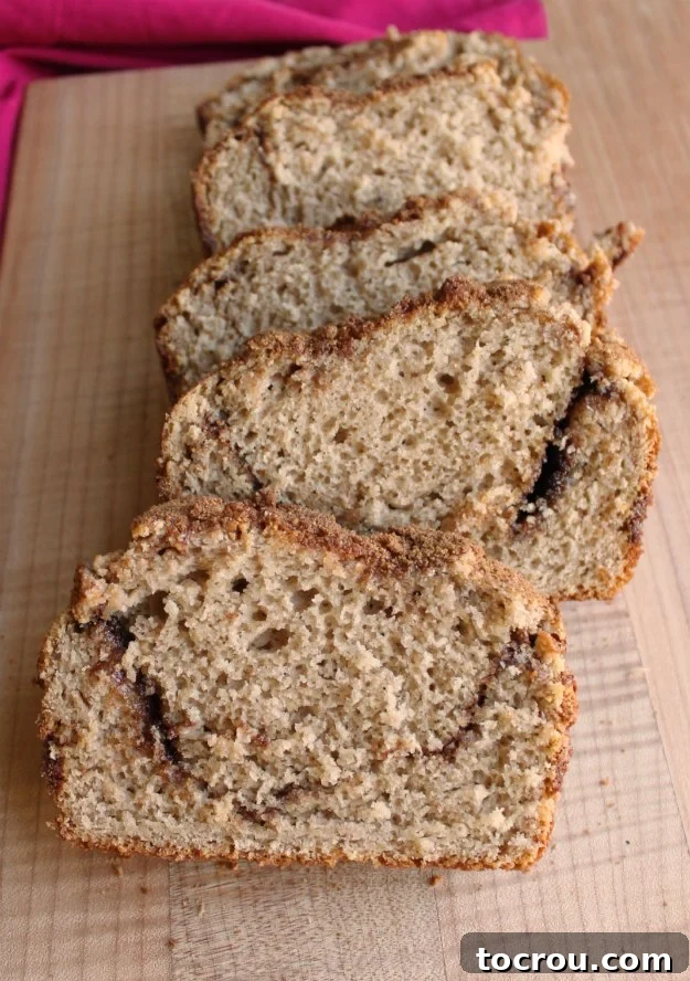 Enjoy beautifully marbled slices of cinnamon swirl quick bread, ready for sharing. Slices of cinnamon swirl quick bread on cutting board.