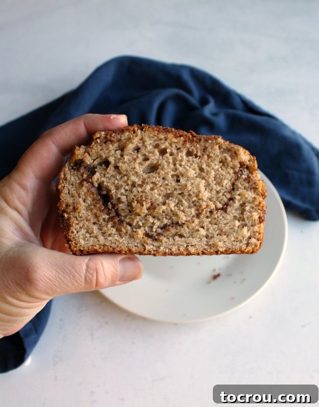 A tempting slice of cinnamon brown sugar bread, perfect for a cozy moment. hand holding slice of cinnamon brown sugar bread
