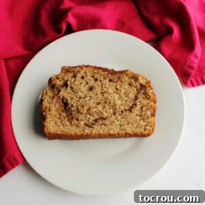 A perfect slice of cinnamon swirl quick bread, ready to be enjoyed. slice of cinnamon swirl bread on small plate ready to eat