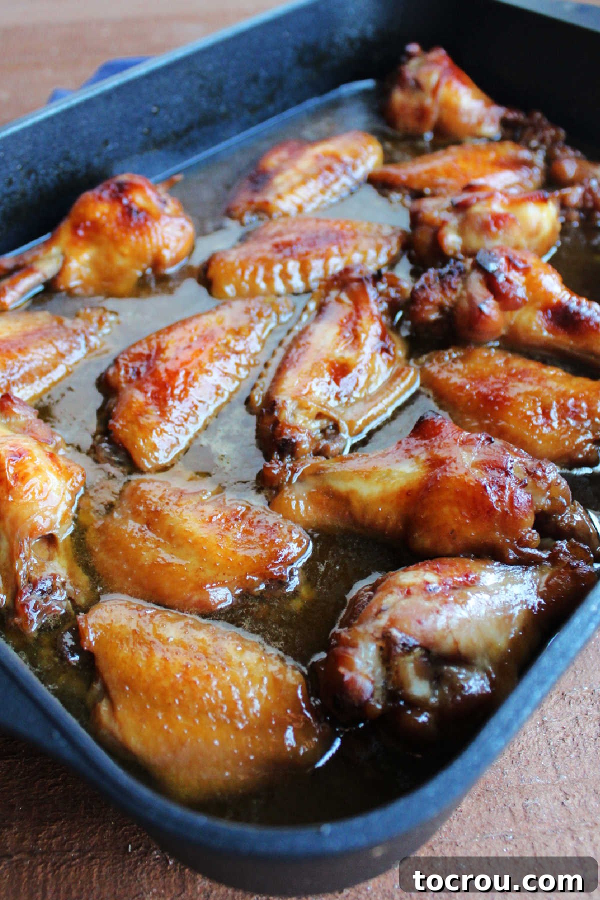 Sticky Caramelized Chicken Wings 4 Pan filled with sticky baked wings fresh from the oven.